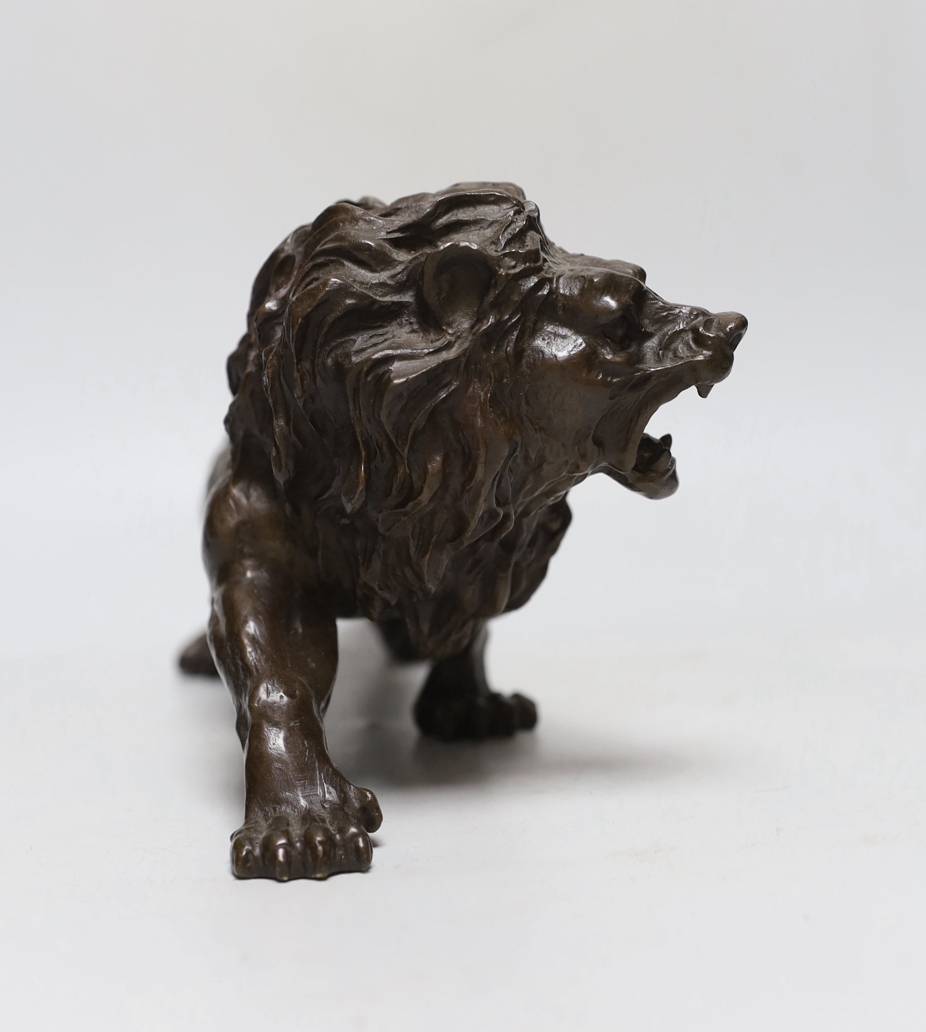 A hollow cast bronze model of a lion, 33cm long